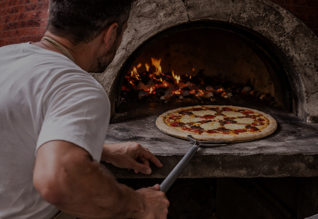Pizzaiolo devant le four napolitain à bois de la Trattoria del Par à Chaudes-Aigues