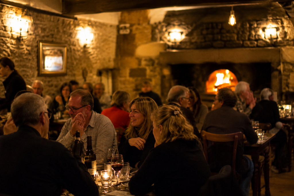 Salle vivante de trattoria à Chaudes-Aigues autour du feu de bois