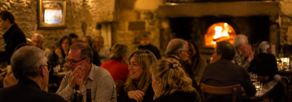 Salle vivante de trattoria à Chaudes-Aigues autour du feu de bois